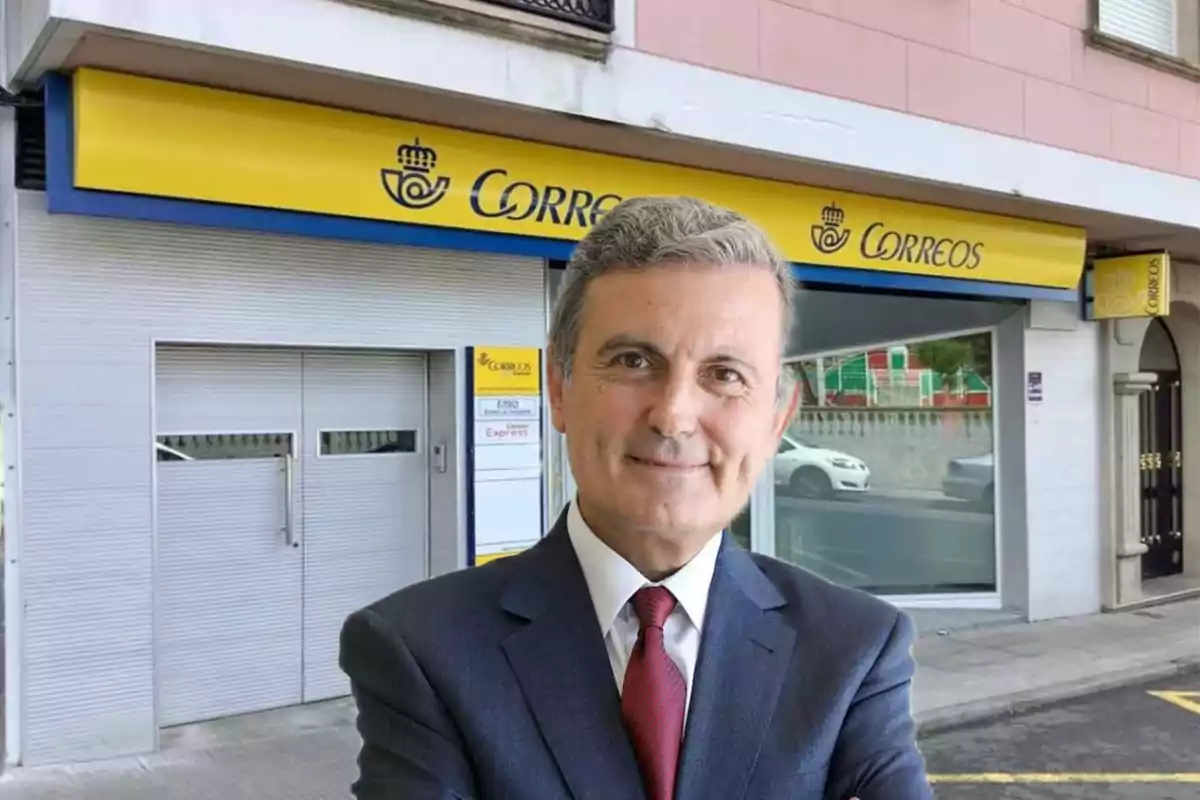 Un hombre de traje y corbata está de pie frente a una oficina de Correos con un letrero amarillo y azul.