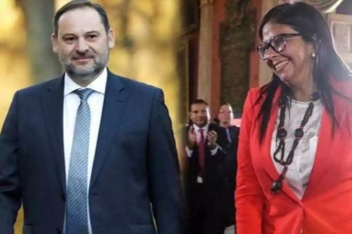 Dos personas vestidas formalmente sonríen en un entorno profesional.