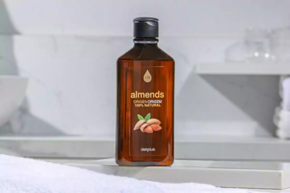 Botella de aceite de almendras sobre una superficie de baño. Botella de aceite de almendras sobre una superficie de baño.