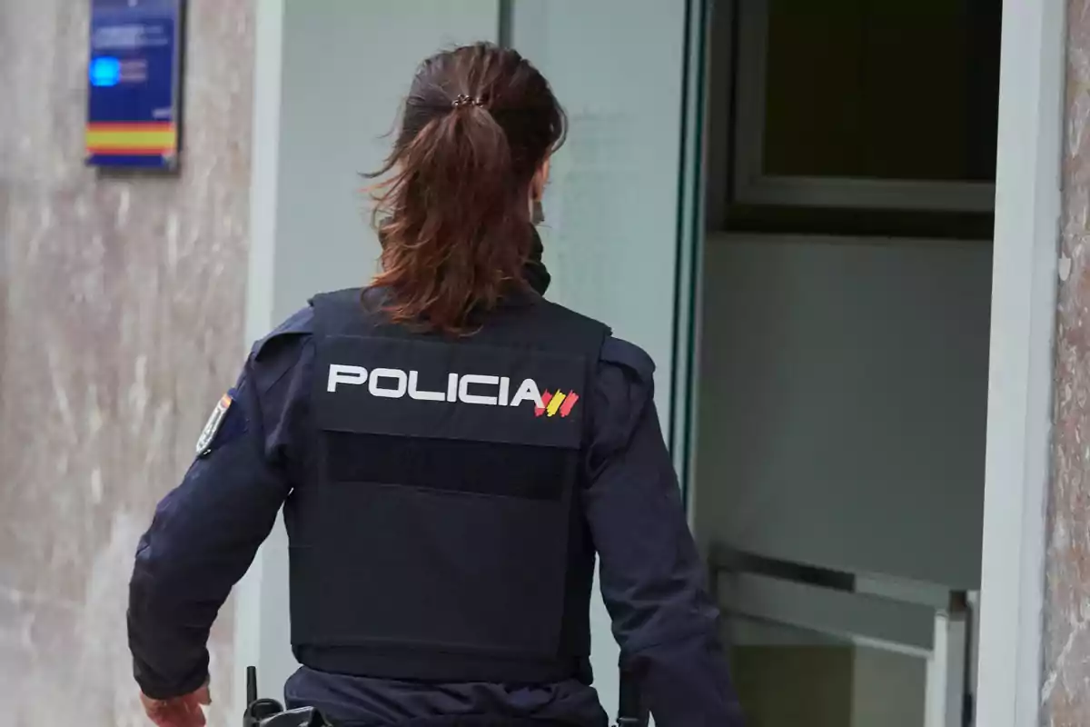 Una agente de policía entrando a un edificio. Una agente de policía entrando a un edificio.