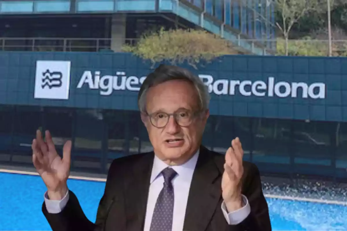 Un hombre con traje y corbata gesticula frente a un edificio con el logo de Aigües de Barcelona.