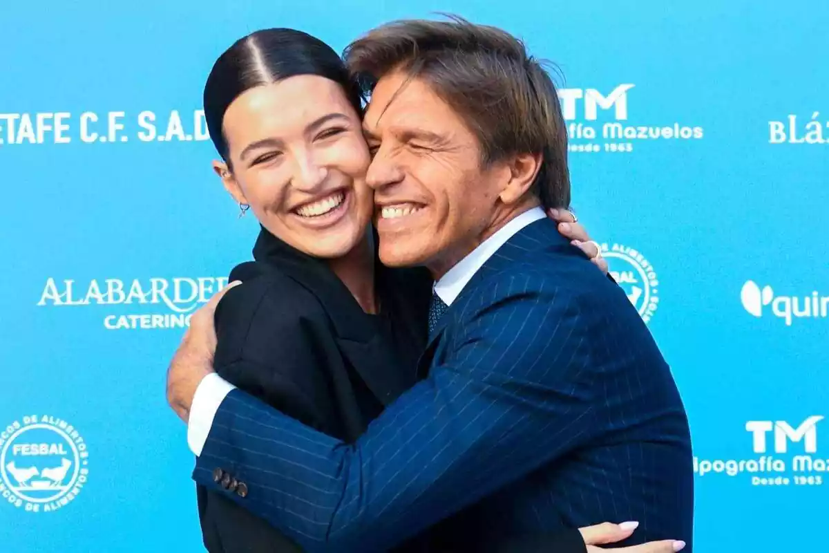 Imagen de la influencer Alba Díaz y su padre Manuel Díaz, El Cordobés, abrazándose. Ella lleva un traje negro y çel uno azul marino Imagen de la influencer Alba Díaz y su padre Manuel Díaz, El Cordobés, abrazándose. Ella lleva un traje negro y çel uno azul marino