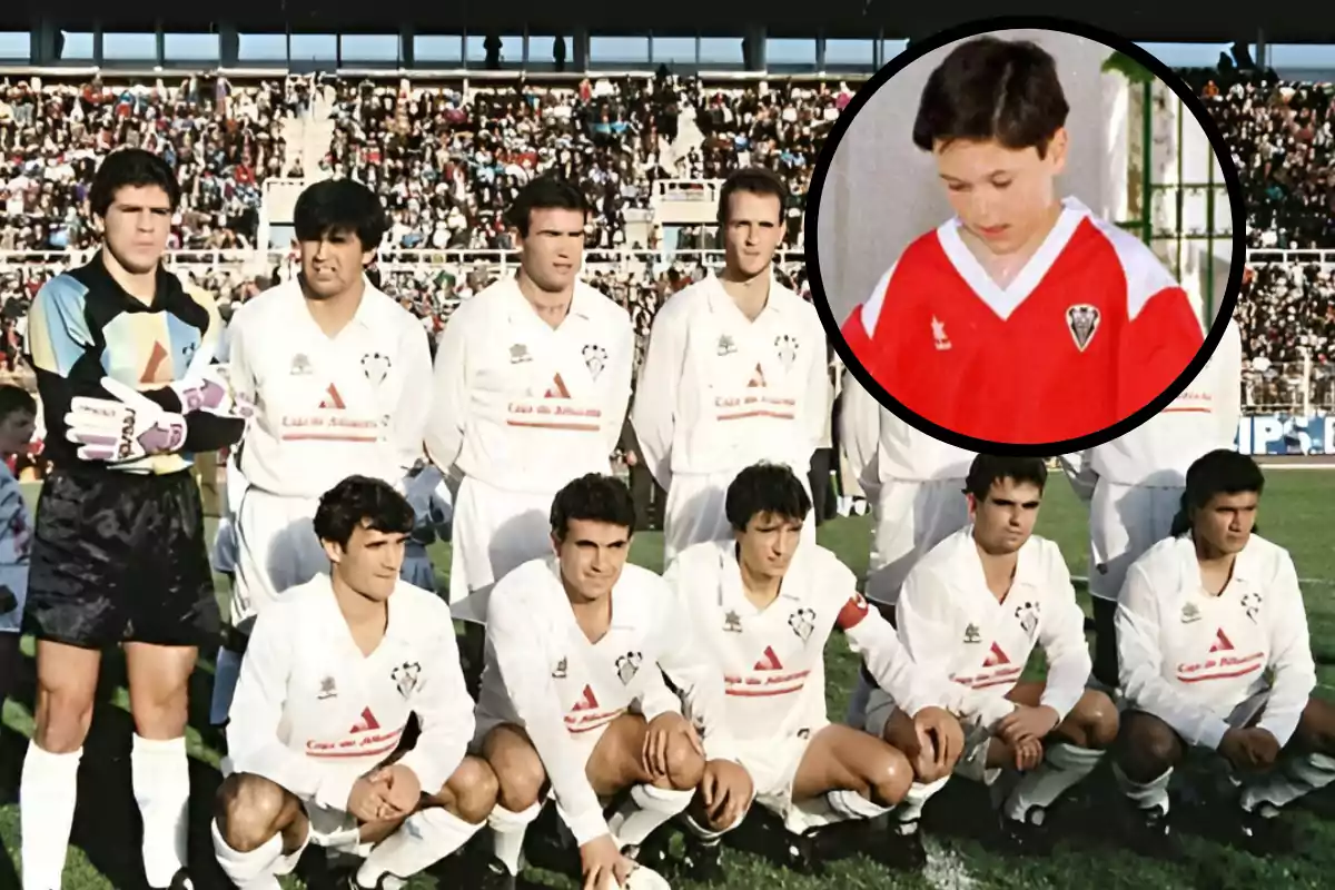 Un equipo de fútbol posando en el campo con un niño en un recuadro usando una camiseta roja.