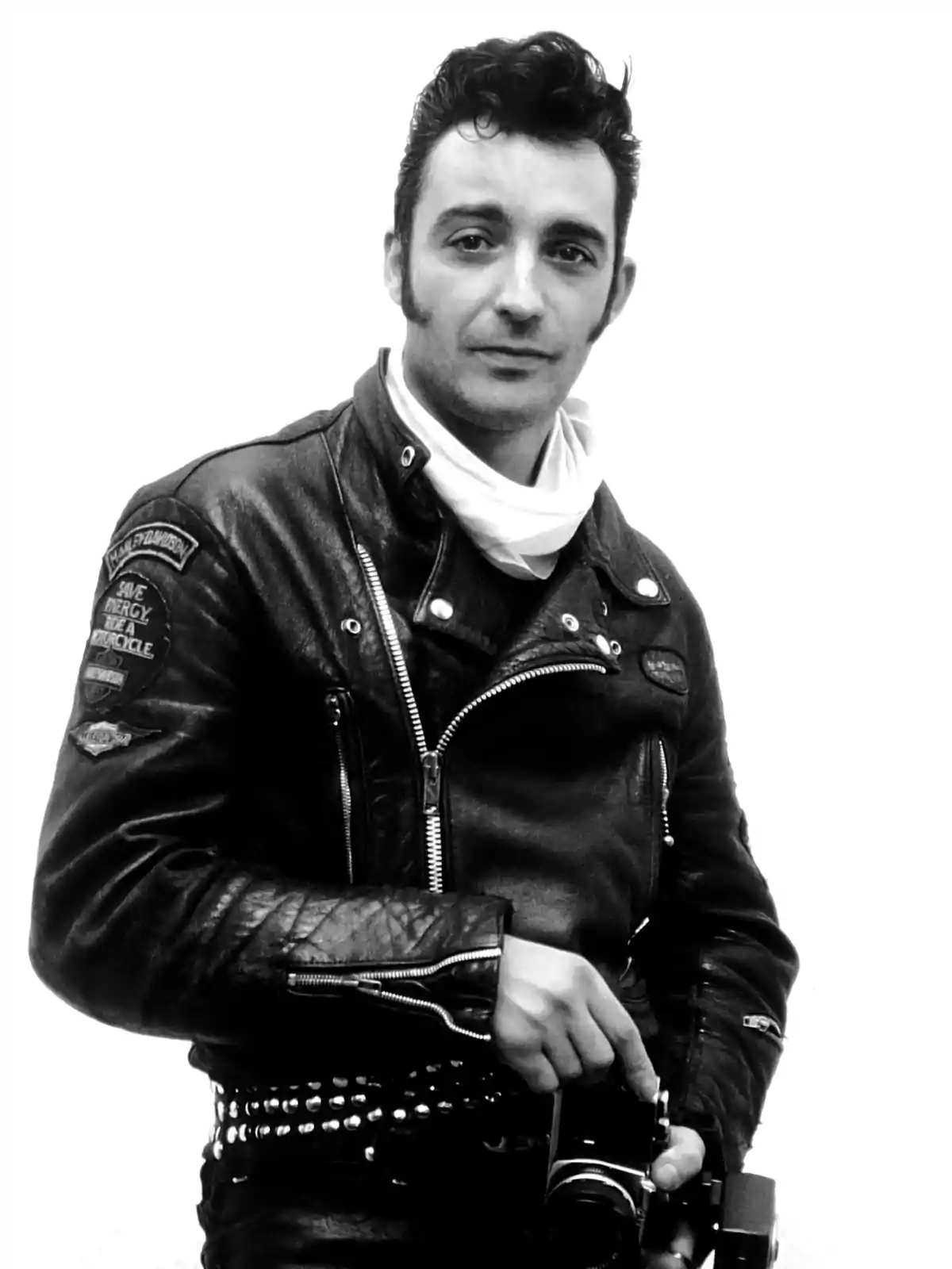 Hombre con chaqueta de cuero negra y bufanda blanca sosteniendo una cámara fotográfica en blanco y negro Hombre con chaqueta de cuero negra y bufanda blanca sosteniendo una cámara fotográfica en blanco y negro