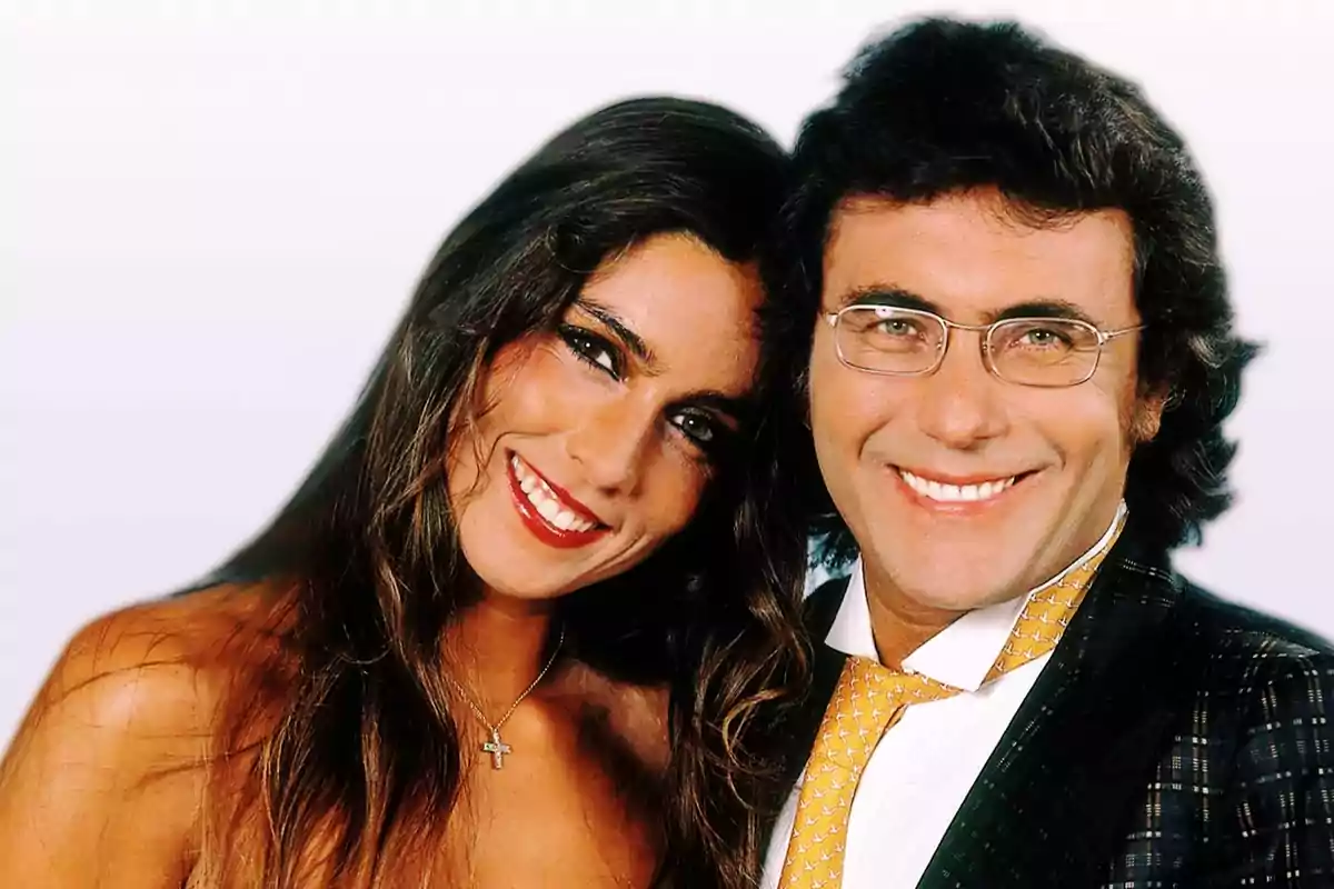 Una pareja sonriente posando juntos frente a un fondo claro. Una pareja sonriente posando juntos frente a un fondo claro.