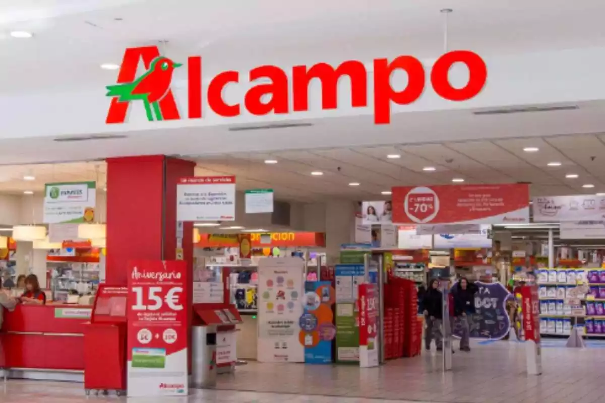 Primer plano exterior de una tienda Alcampo, con el logo de la cadena en color rojo Primer plano exterior de una tienda Alcampo, con el logo de la cadena en color rojo