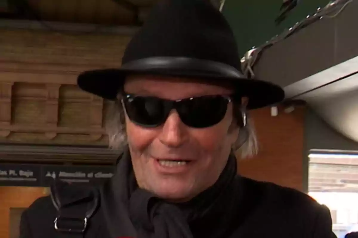 Amador Mohedano con sombrero negro y gafas de sol sonríe mientras está en un lugar público. Amador Mohedano con sombrero negro y gafas de sol sonríe mientras está en un lugar público.