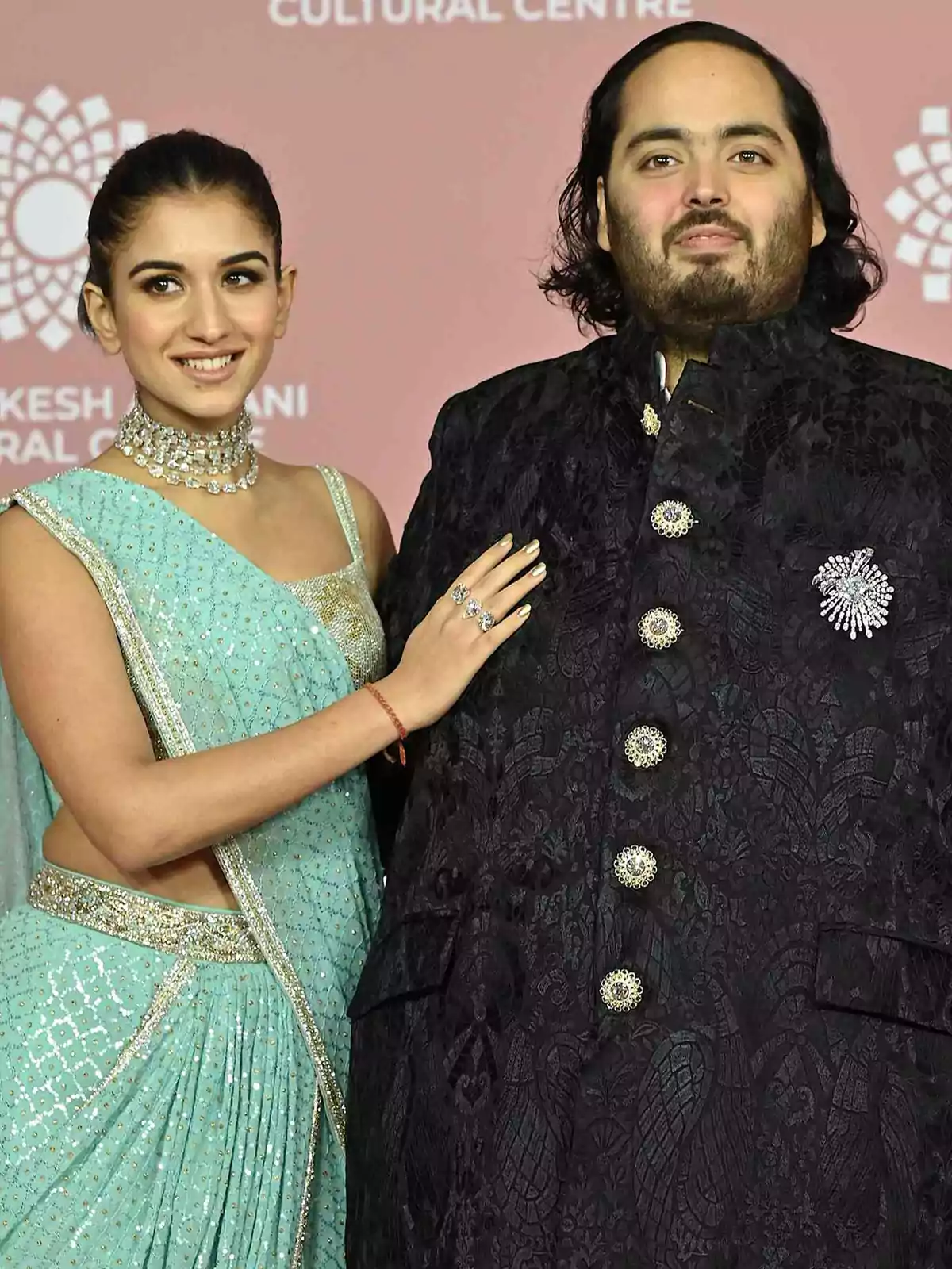 Una pareja posando en un evento formal con trajes tradicionales.