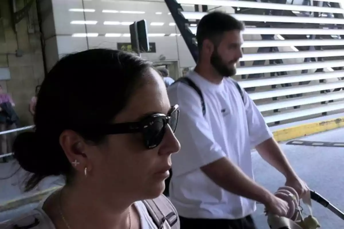 Anabel Pantoja con gafas de sol y David Rodríguez con camiseta blanca empujando un cochecito de bebé en un entorno urbano. Anabel Pantoja con gafas de sol y David Rodríguez con camiseta blanca empujando un cochecito de bebé en un entorno urbano.