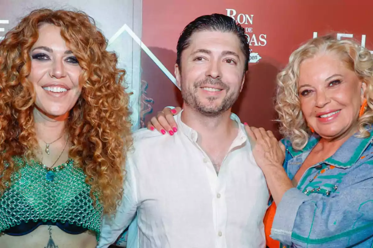 Tres personas posando juntas y sonriendo frente a un fondo rojo. Tres personas posando juntas y sonriendo frente a un fondo rojo.
