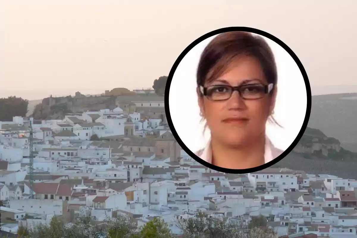 Una imagen de un pueblo con casas blancas y una colina al fondo, sobre la cual hay un círculo que muestra el rostro de una persona con gafas.