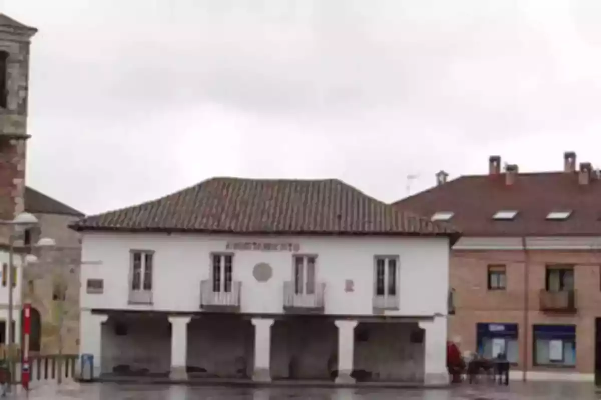 Edificio histórico con techo de tejas y fachada blanca en un día nublado.