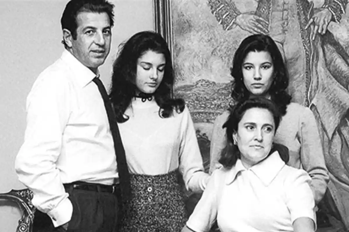 Una familia posando para una fotografía en blanco y negro frente a un cuadro.