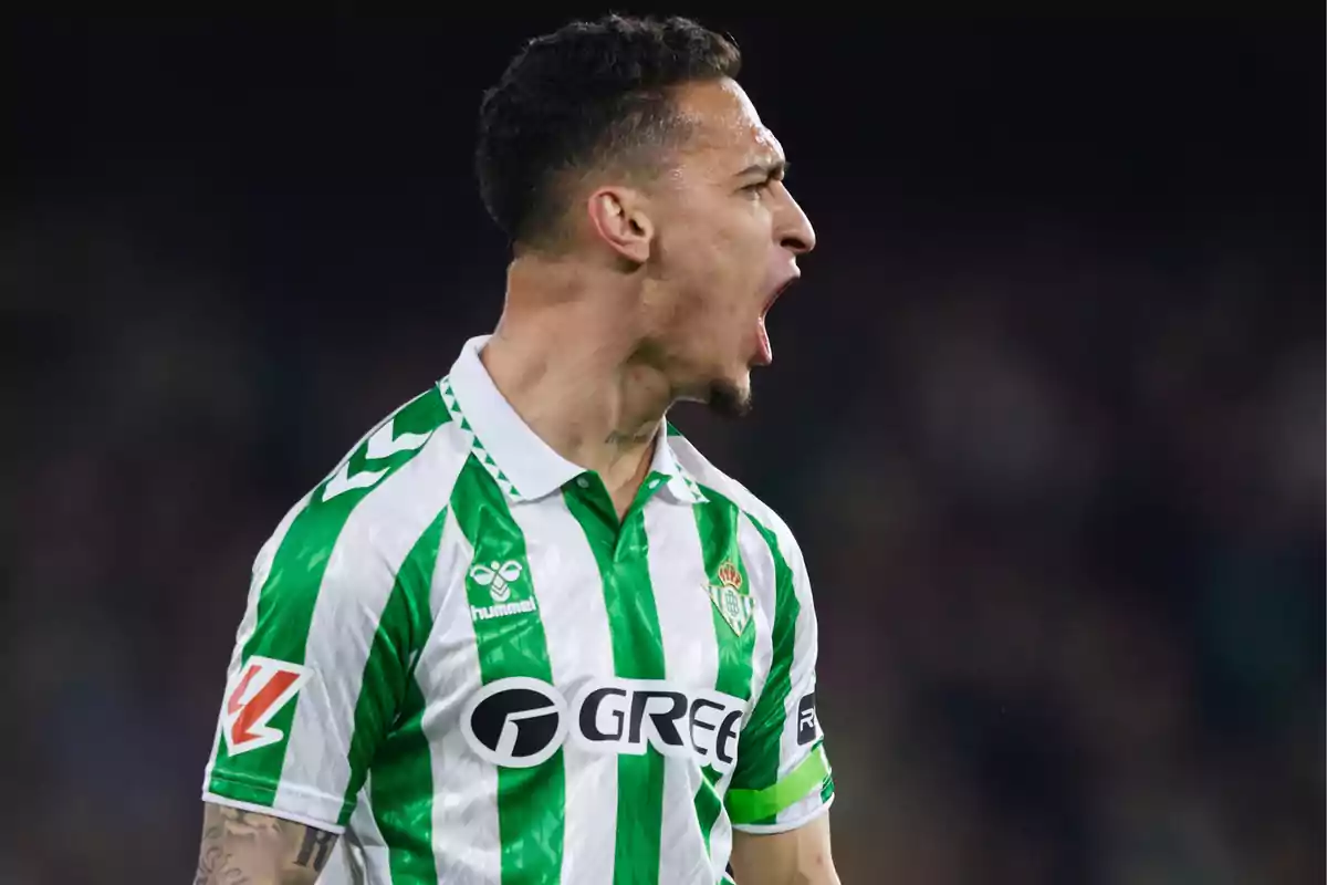 Un jugador de fútbol con uniforme verde y blanco grita con emoción durante un partido. Un jugador de fútbol con uniforme verde y blanco grita con emoción durante un partido.