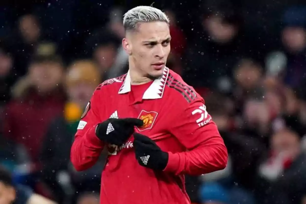Jugador de fútbol con uniforme rojo en el campo durante un partido. Jugador de fútbol con uniforme rojo en el campo durante un partido.