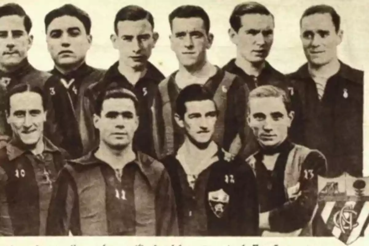 Un grupo de jugadores de fútbol posando juntos con camisetas numeradas en una fotografía antigua.