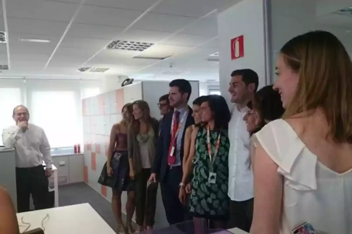 Un grupo de personas sonríe mientras posa para una foto en una oficina iluminada.