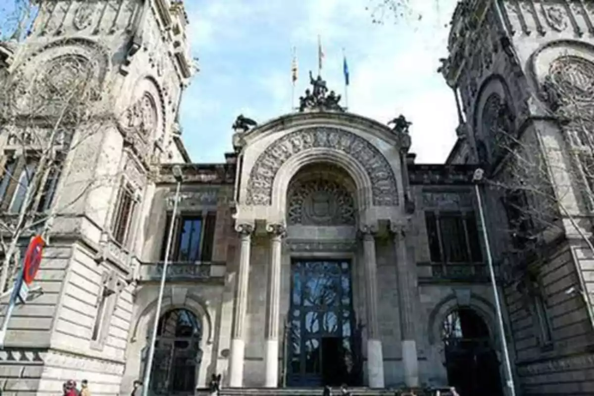 Fachada de un edificio histórico con detalles arquitectónicos ornamentados y columnas en la entrada.