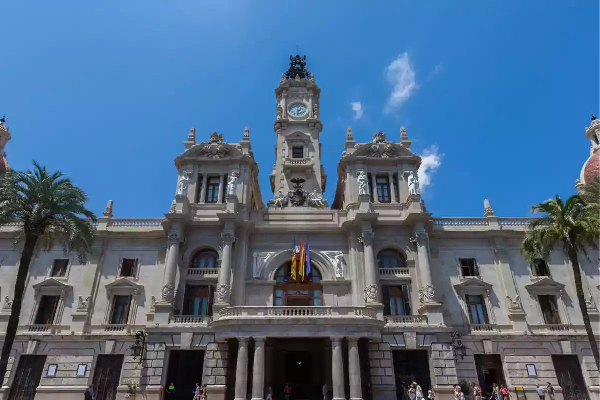 Fachada del ayuntamiento de Valencia con cielo azul y palmeras a los lados Fachada del ayuntamiento de Valencia con cielo azul y palmeras a los lados