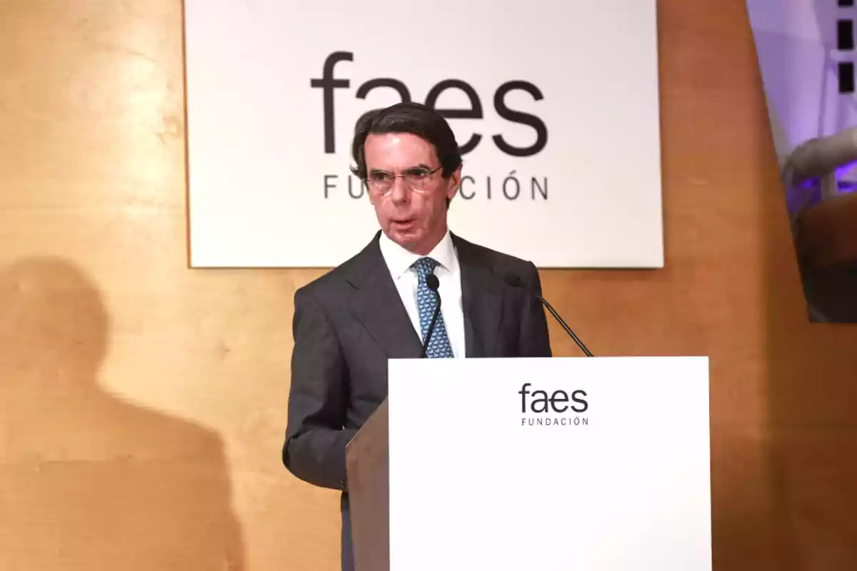 Un hombre en traje habla en un podio con el logo de la Fundación FAES al fondo.