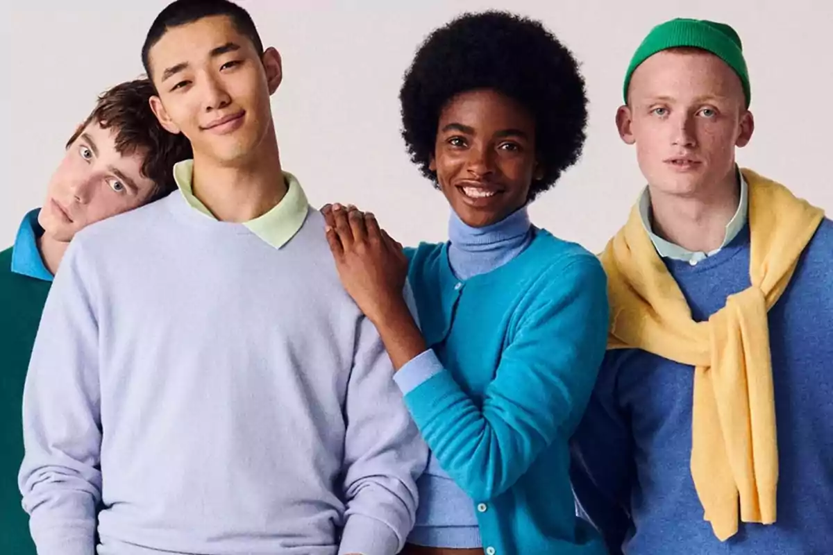 Un grupo de cuatro personas posando juntas con ropa colorida y sonriendo.