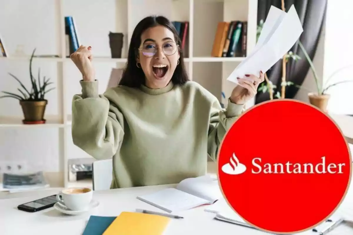 Una mujer sonriente con gafas y suéter verde celebra mientras sostiene unos papeles, con el logotipo de Santander en primer plano.