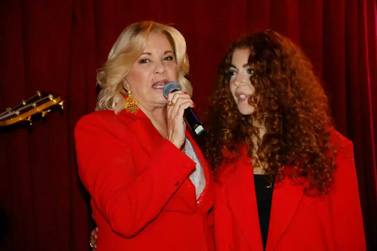 Bárbara Rey y Sofía Cristo vestidas de rojo en un escenario, una de ellas sosteniendo un micrófono. Bárbara Rey y Sofía Cristo vestidas de rojo en un escenario, una de ellas sosteniendo un micrófono.