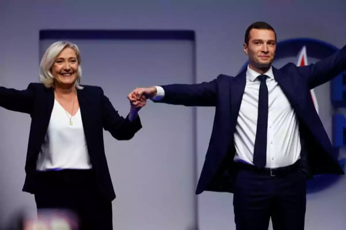Dos políticos franceses levantan los brazos en señal de victoria.