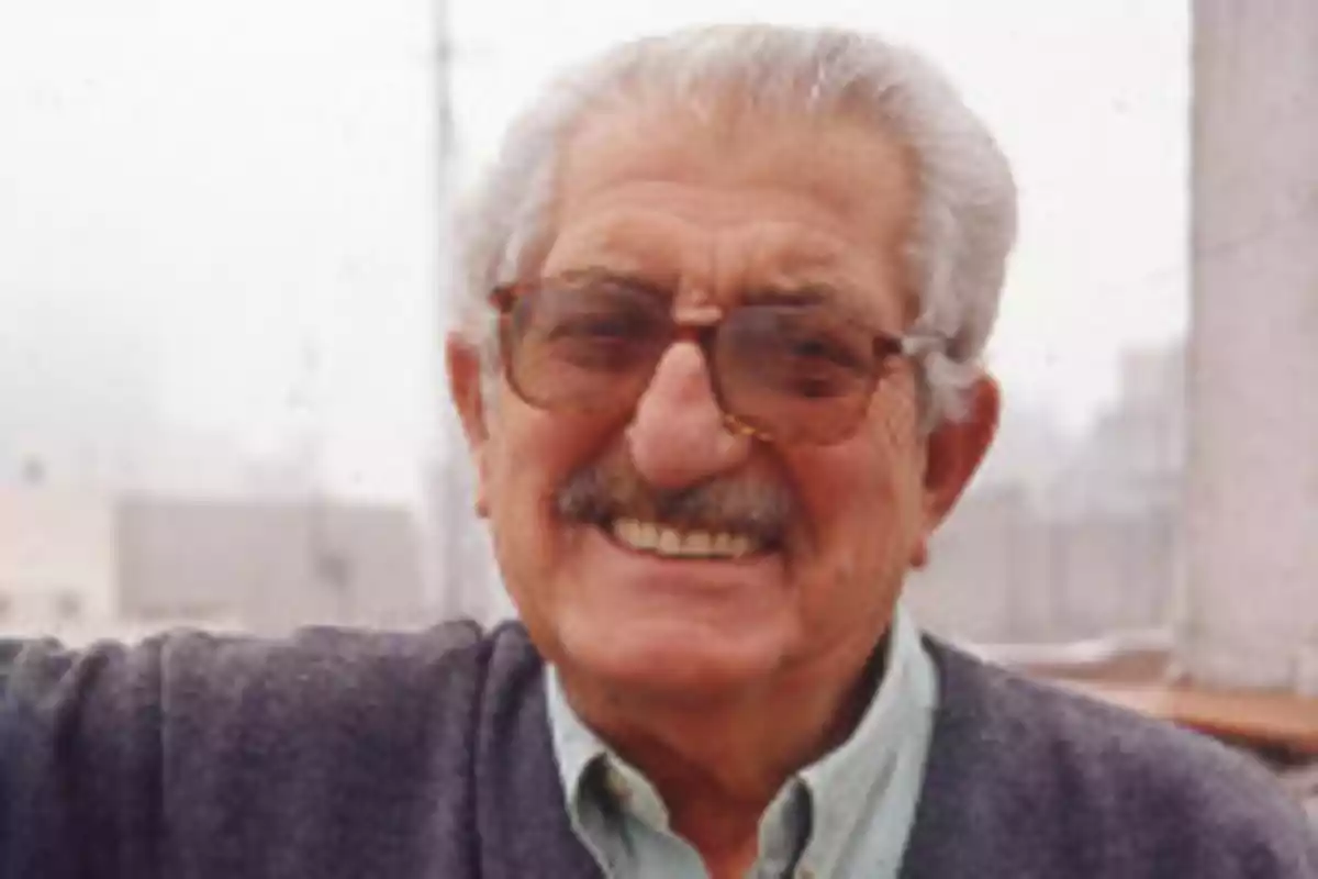 Un hombre mayor con gafas y bigote sonríe al aire libre. Un hombre mayor con gafas y bigote sonríe al aire libre.