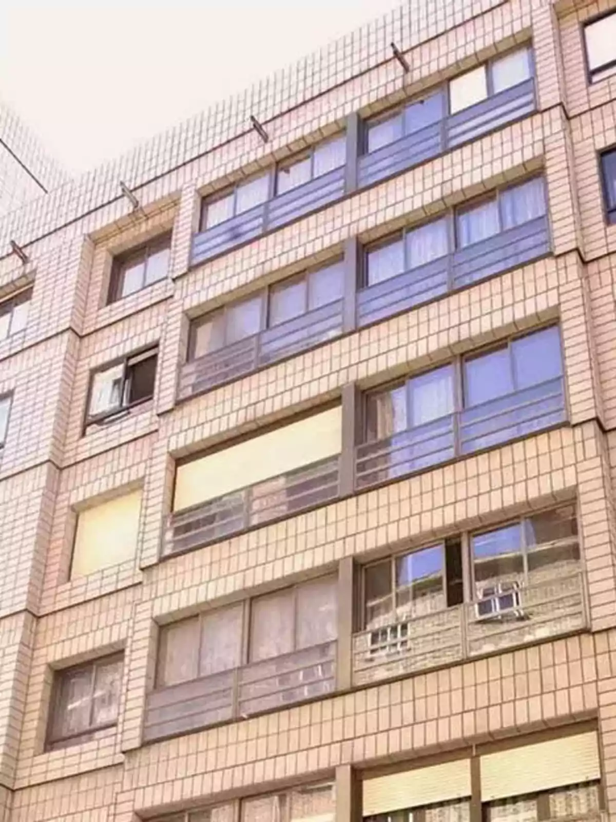 Edificio de apartamentos con fachada de azulejos y varias ventanas.