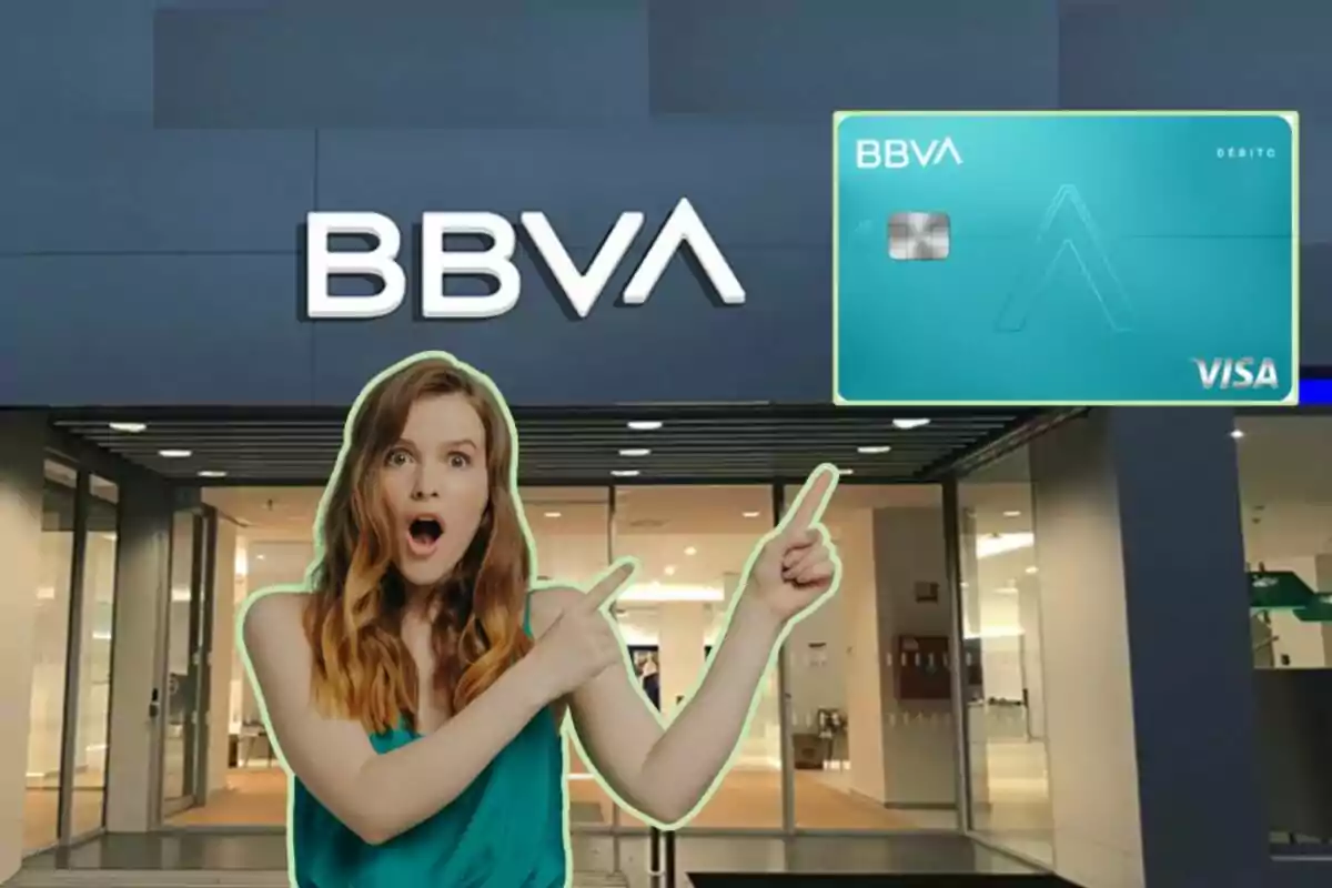 Mujer sorprendida señalando una tarjeta de débito BBVA frente a una sucursal del banco.