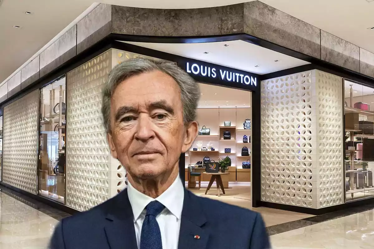 Un hombre de traje frente a una tienda de Louis Vuitton.