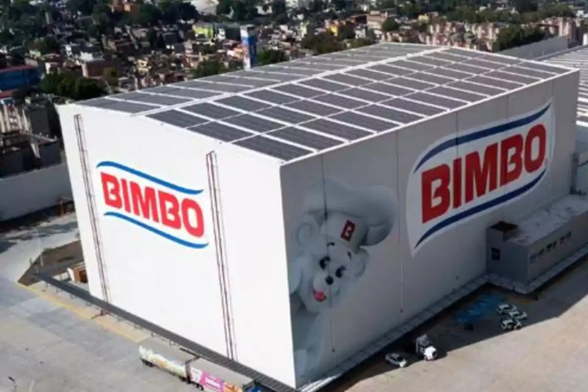 Vista aérea de una planta de producción de Bimbo con paneles solares en el techo y el logotipo de la empresa en las paredes.