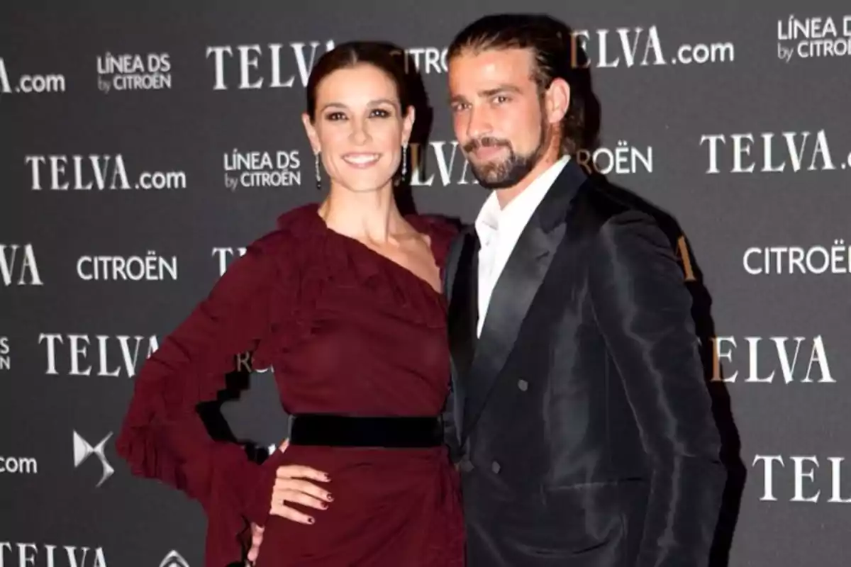 Pareja posando elegantemente en una alfombra roja frente a un fondo con logotipos de Telva y Citroën