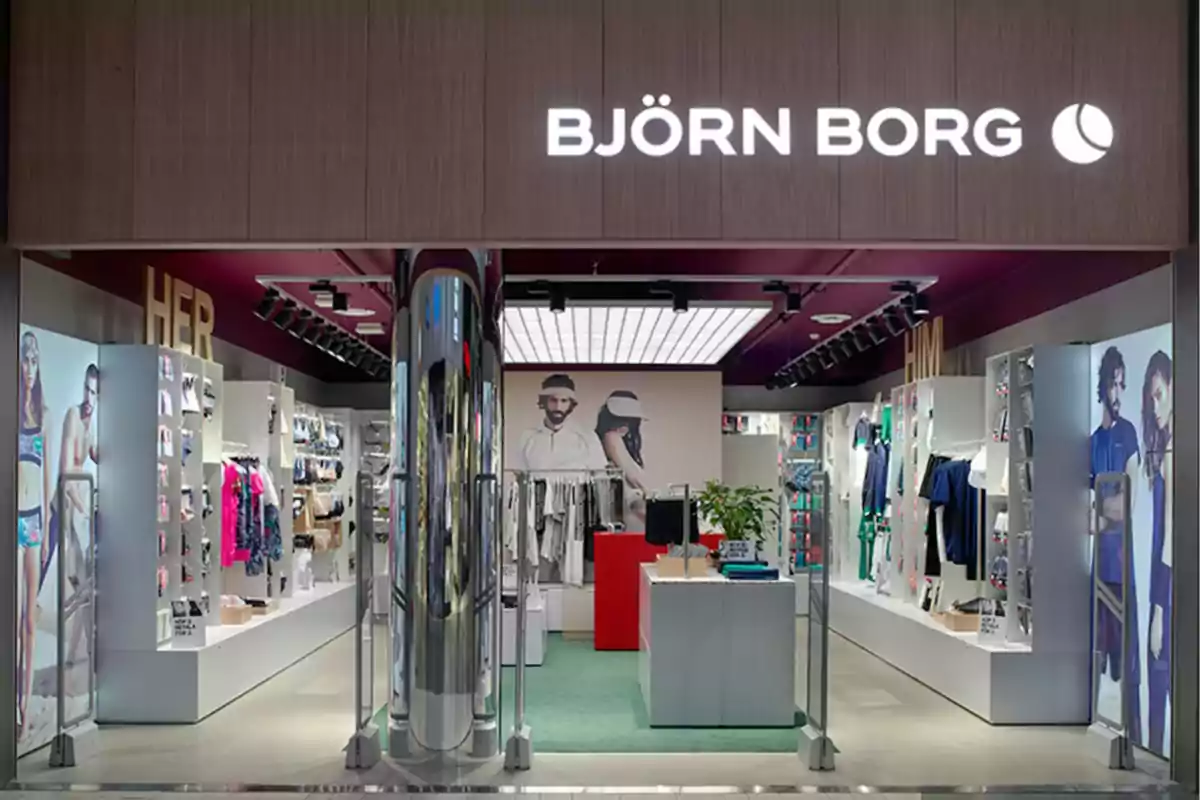 Tienda de ropa Björn Borg con escaparate iluminado y exhibición de productos deportivos en su interior.