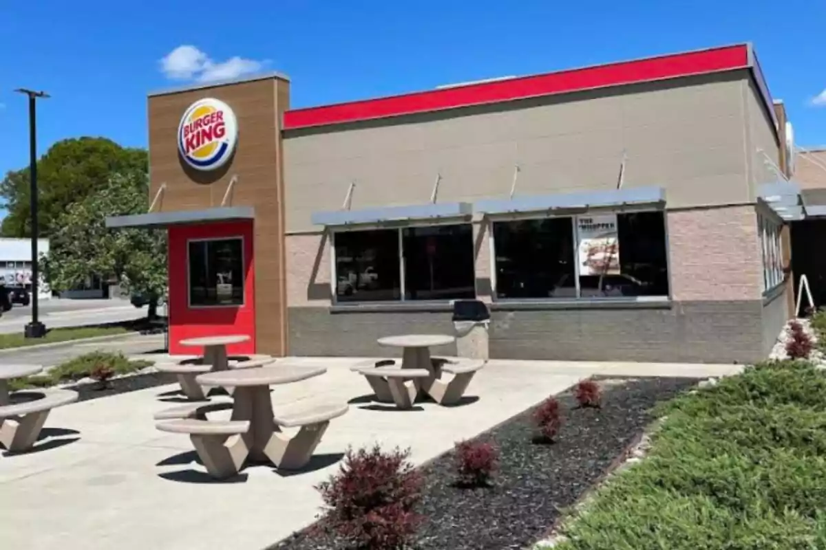 Restaurante de comida rápida Burger King con mesas de concreto al aire libre y un cielo despejado Restaurante de comida rápida Burger King con mesas de concreto al aire libre y un cielo despejado