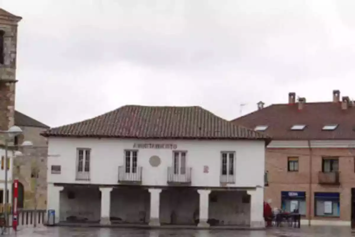 Edificio de un ayuntamiento con techo de tejas y balcones en un día nublado.