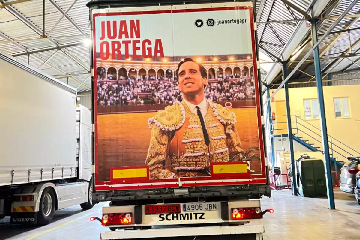 Un camión con una imagen de un torero en la parte trasera, con el nombre "Juan Ortega" en letras rojas y sus redes sociales.