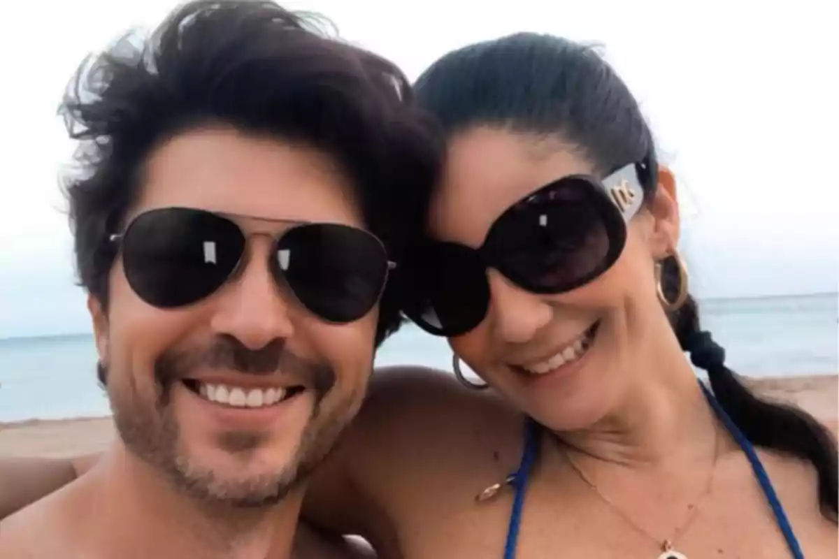 Una pareja sonriente con gafas de sol en la playa. Una pareja sonriente con gafas de sol en la playa.
