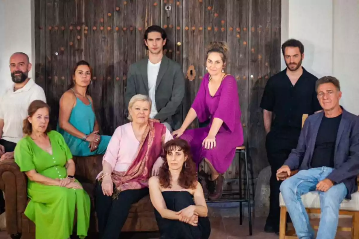 Un grupo de personas posando frente a una puerta de madera.