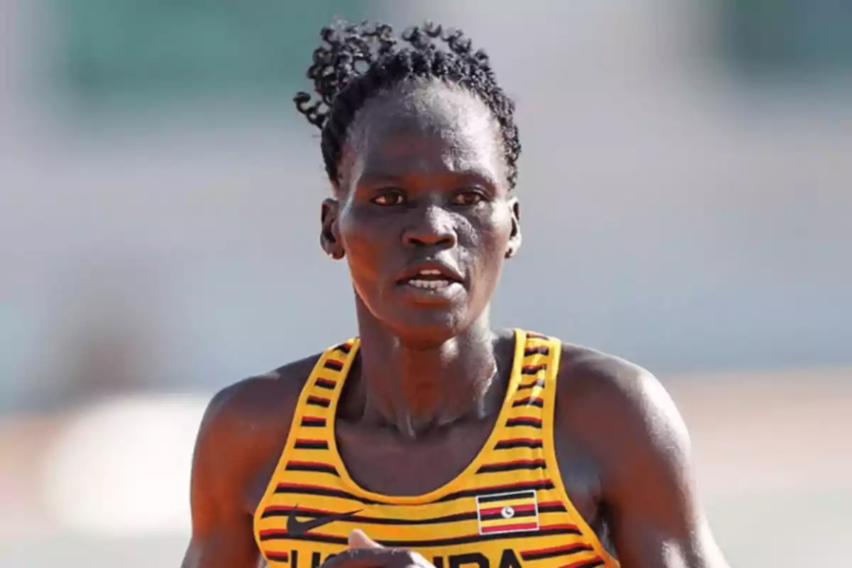 Atleta con uniforme de Uganda corriendo en una competencia.