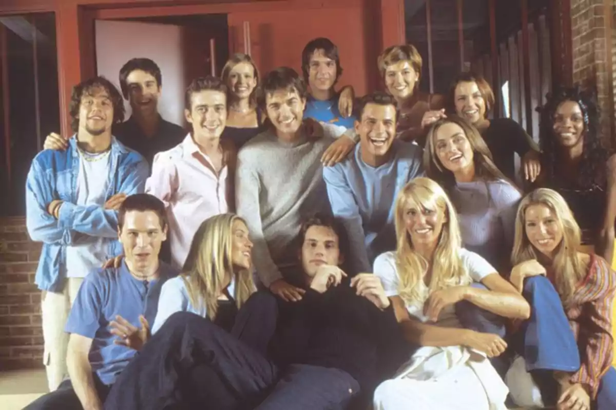 Un grupo de personas jóvenes posando juntas y sonriendo en un ambiente interior.