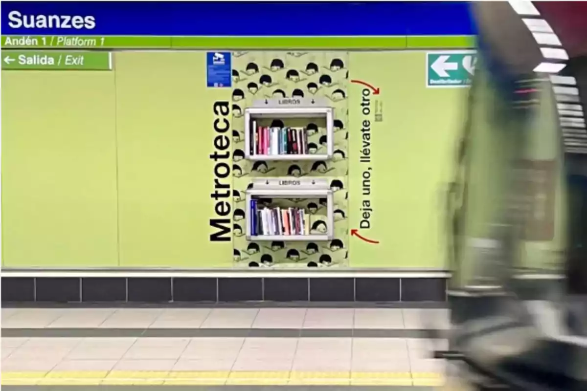 La imagen muestra una estación de metro llamada Suanzes, con un letrero verde que indica "Salida/Exit" y una "Metroteca" con estantes llenos de libros, acompañada de la frase "Deja uno, llévate otro".