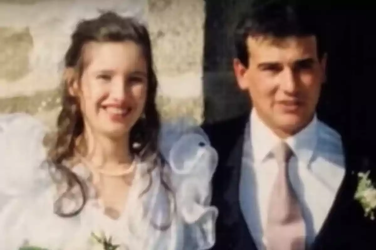 Una pareja sonriente vestida de novios posando para una foto en su boda.