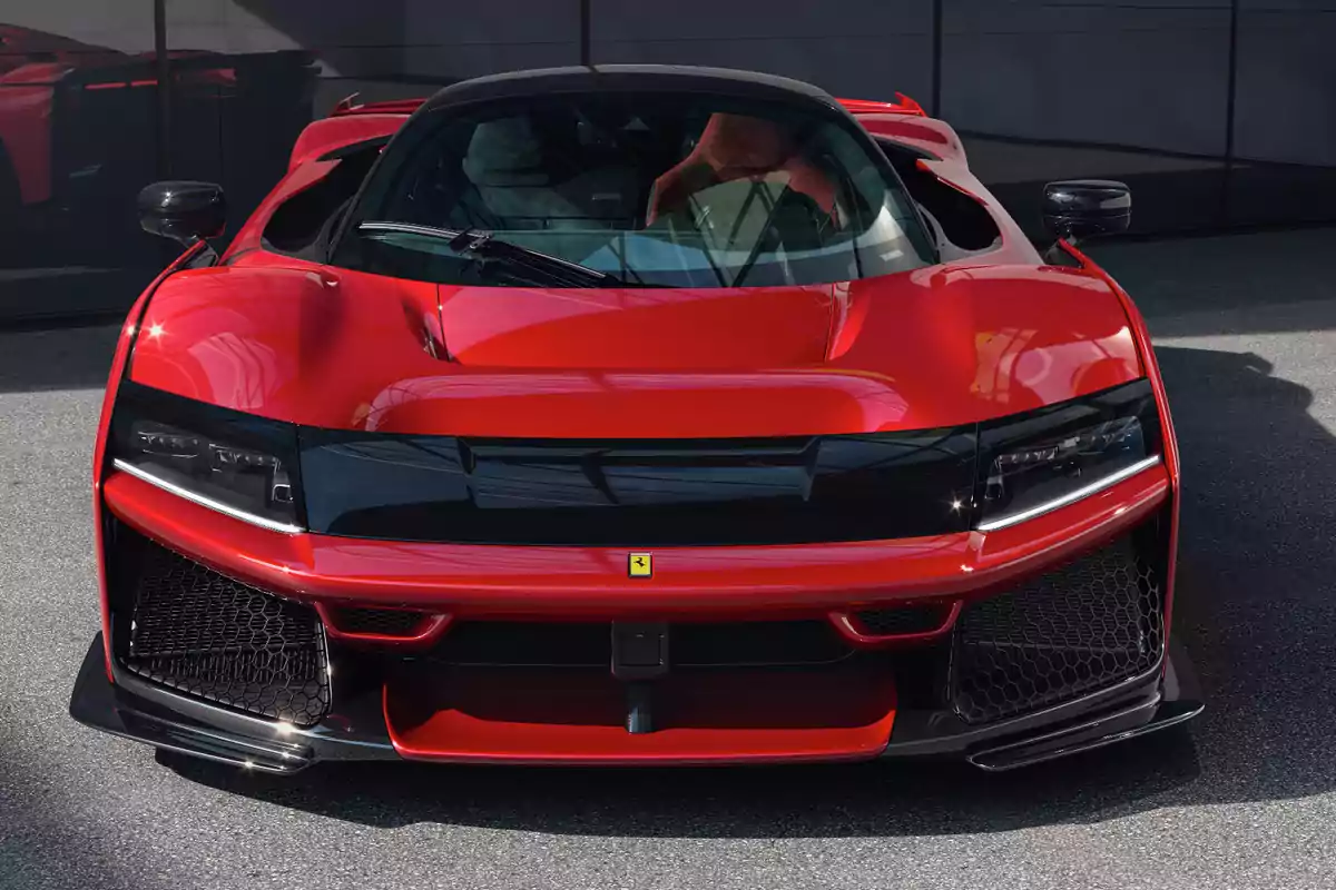 Un Ferrari F80 deportivo rojo con diseño aerodinámico y detalles en negro estacionado en un área pavimentada.