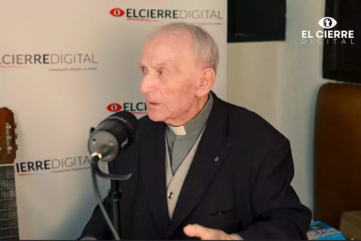 El padre Bartolomé Rizo con vestimenta clerical habla frente a un micrófono en un estudio con el logo de El Cierre Digital en el fondo.