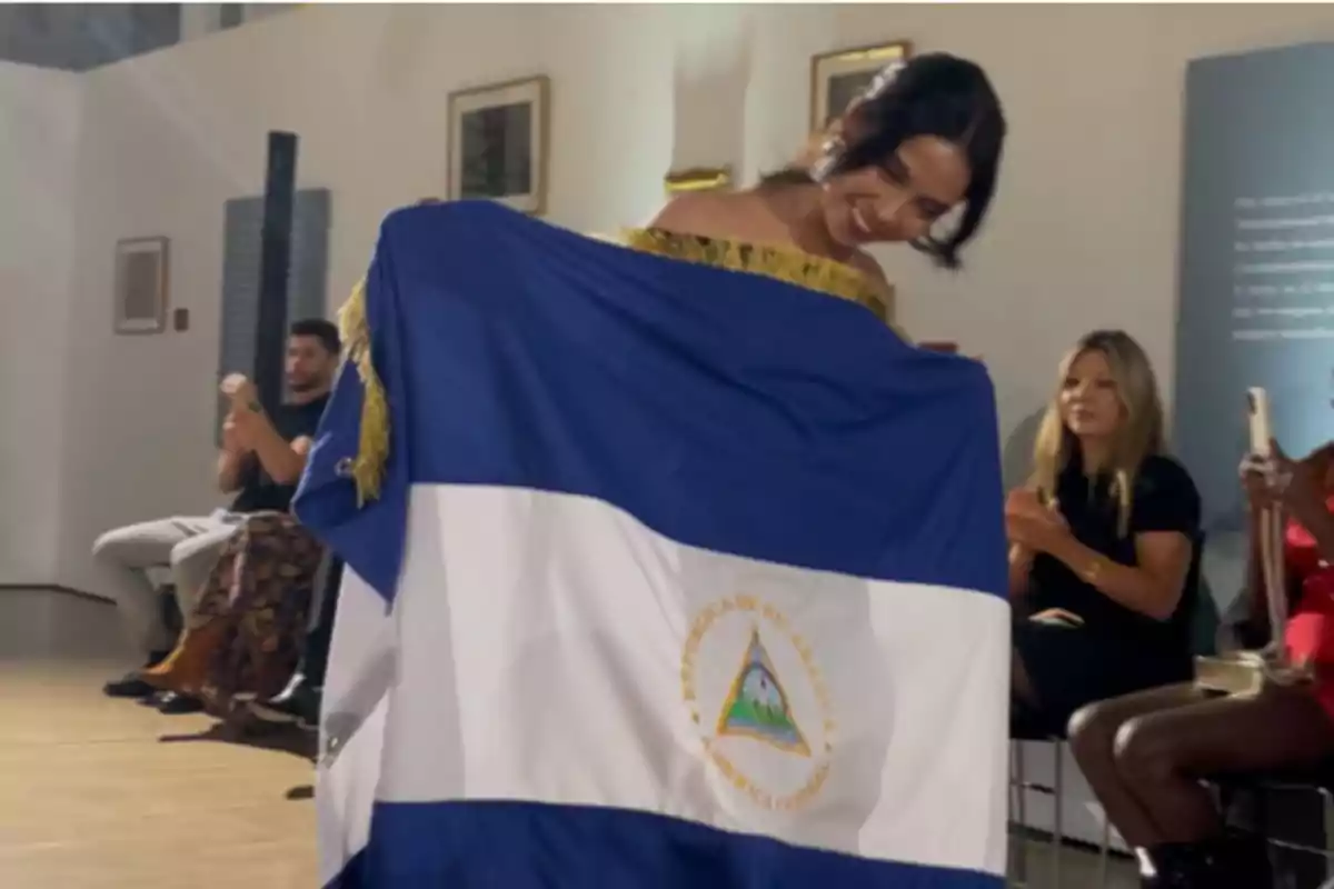 Brisa Hernández tras presentar su colección con la bandera de Nicaragua.