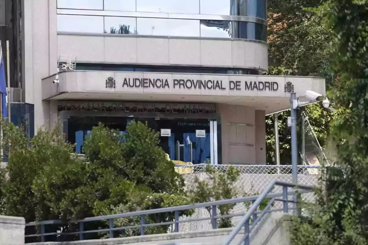 Fachada de la Audiencia Provincial de Madrid con árboles y cámaras de seguridad en el exterior.