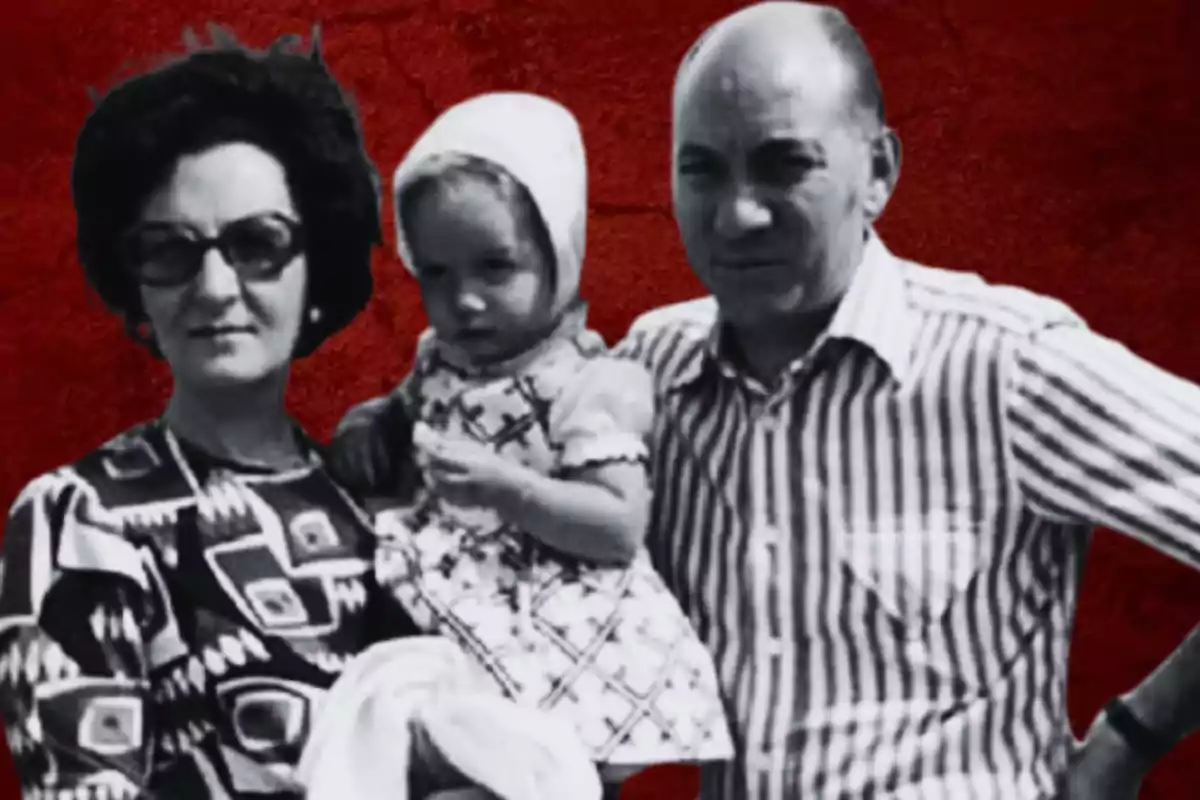 Una familia posando para una foto en blanco y negro con un fondo rojo.