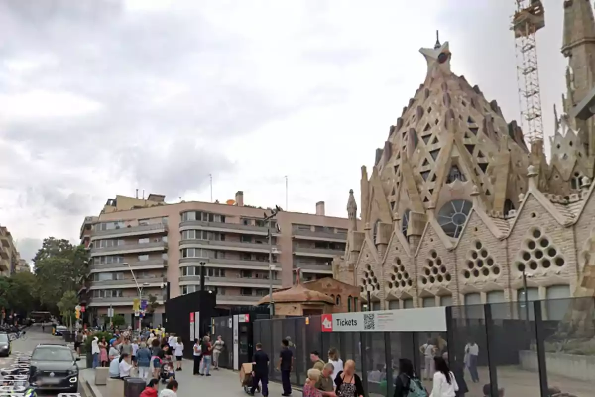 Personas caminando cerca de un edificio con arquitectura elaborada y moderna en una ciudad.